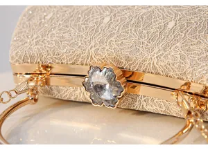 Elegant gold frame lace evening clutch bag detail, sparkling crystal flower clasp and handle.