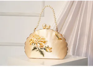 Goldene Muschel-Abendtasche mit bestickten Pfingstrosen, Perlenhenkel und Perlenverschluss.