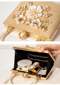 Gold glitter evening clutch bag with pearl and shell flower embellishment, elegant design.