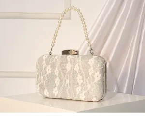 Gros plan détaillé du sac de soirée en dentelle blanche avec poignée de perles.
