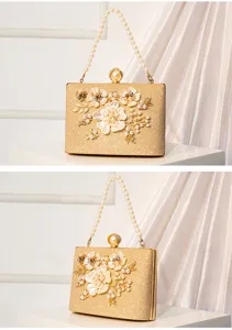 Close-up detail of gold glitter evening clutch bag with pearl handle and floral appliques.