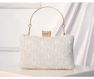 Elegant lace sequin evening clutch bag detail showing sparkling rhinestone clasp and handle.