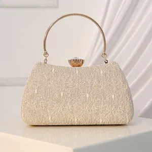 Elegant beige lace evening clutch bag with gold round metal handle for wedding party.