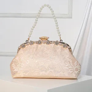 Champagne lace clutch handbag with elegant pearl handle and sparkling rhinestone clasp.