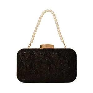 Élégante pochette de soirée noire avec poignée en perles et dentelle de sequins.