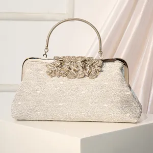 Elegant vintage lace evening bag with metal handle and rhinestone leaf clasp for parties.