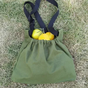 Green canvas outdoor foraging bag detail, bushcraft fruit picking pouch with straps and buckles.