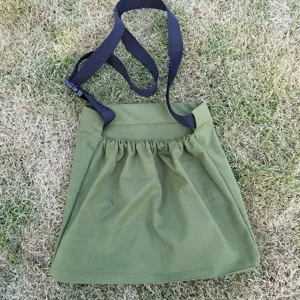 Outdoor foraging harvest bag detail view showcasing green fabric and adjustable black strap.