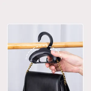 Closet arched bag hanger detail view, black plastic multi-functional organizer for purses.
