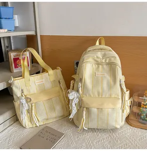Close-up of cute yellow striped backpack and tote bag set with lace ribbon pendant and pockets.
