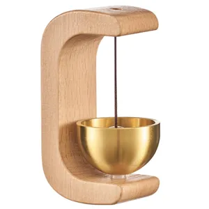Primer plano de timbre de puerta magnético de madera con soporte en C y campana de latón.