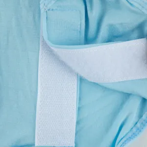 Close-up detail of blue pet recovery suit fabric and secure velcro closure strap.