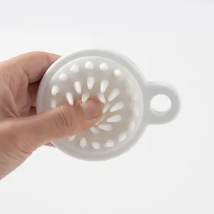 Dettaglio della spazzola per massaggio del cuoio capelluto in silicone morbido.