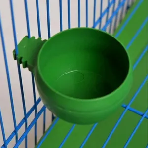 Green plastic bird food bowl detail view, durable hanging feeding cup for wire cages.