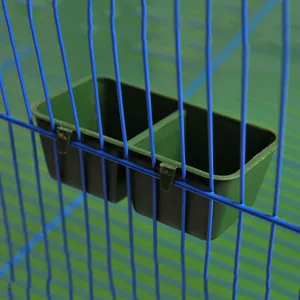Close-up view of the double-cup bird feeder hanging inside a wired cage, showing structure.