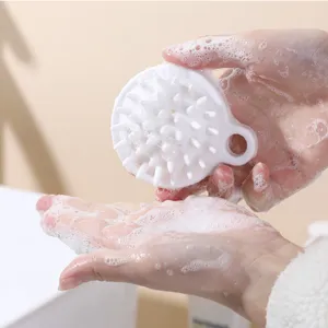 Primo piano di una spazzola per massaggio del cuoio capelluto in silicone bianco per lavaggio.