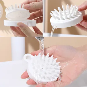 Dettaglio di una spazzola per massaggio cuoio capelluto in silicone bianco morbido.