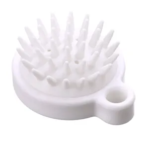 Vista dettagliata della spazzola per cuoio capelluto in silicone bianco con setole morbide.
