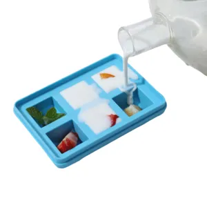 Vue détaillée du bac à glaçons en silicone montrant le remplissage avec des fruits frais.