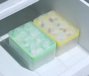 Gros plan de bacs à glaçons en forme de brique empilables avec couvercle dans le congélateur.