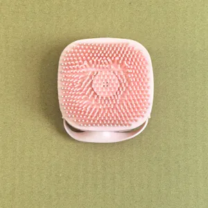 Detailansicht mit weichen Silikonborsten und bequemer Handschlaufe der rosa Haustierbürste.