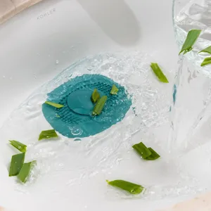 Gros plan sur le bouchon d'évier en silicone vert filtrant l'eau et les débris.