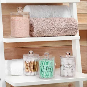 Clear acrylic storage jars with lids for cotton swabs, floss picks and cotton balls.