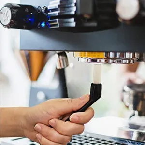 Detail view of a black nylon coffee machine group head cleaning brush in use, practical tool.