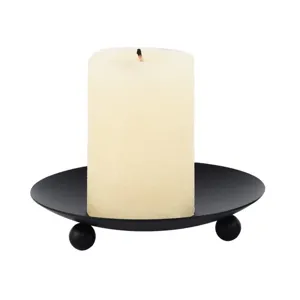 Primer plano detallado de bandeja de portavelas de metal negro con vela para decoración.