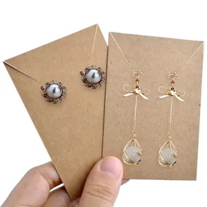 Vista dettagliata di eleganti orecchini alla moda presentati su cartoncini in carta kraft.