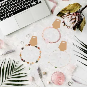 Detailed flat lay shot showing jewelry display cards and assorted bracelets on textured surface.