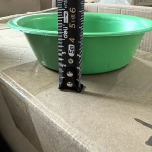 Green plastic washing basin detail view showcasing product height measurement with tape.