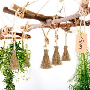 Detailed view of Halloween mini broom hanging ornament with rustic wood frame and herbs.