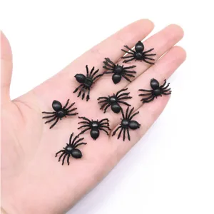 Mini zwarte plastic spinnen in hand, ideaal voor Halloween feestgrappen en griezelige decoratie items.
