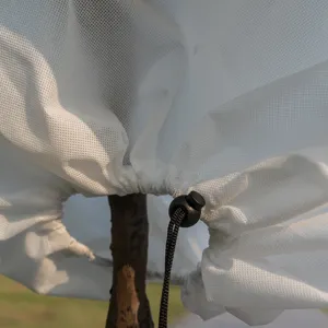 Detalle en primer plano de funda de protección de invierno para plantas con cordón ajustable.