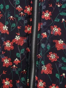 Close-up detail shot of floral print padded jacket fabric with central black zipper