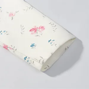 Floral print blazer fabric detail showcasing soft pastel pink and blue flowers on white cloth.