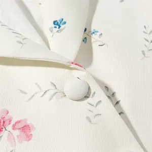 Close-up detail of the floral blazer lapel, showcasing elegant floral print and fabric button.