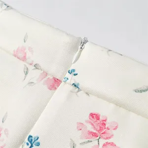 Close up view of the floral print skirt detail, featuring hidden zipper and elegant white fabric.