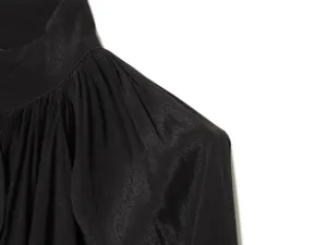 Zwarte blouse schouder detail, hoge kraag met geplooid stof ontwerp en gladde textuur.