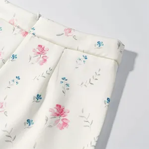 Detail shot of women's floral print skirt, showcasing delicate pink flowers and fine fabric.