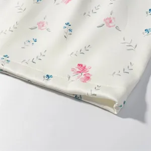 Detailed view of white fabric with floral print, fine stitching for women skirt set.