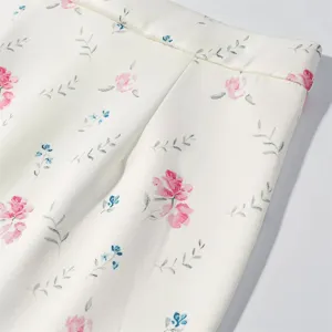 Floral print skirt fabric detail showing exquisite pink and blue flower patterns close up.