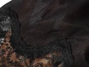 Detail van het zwarte kanten overhemd met fijne stoftextuur en elegant vrouwelijk design.