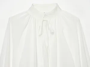 Witte blouse kraag detail close-up, elegante opstaande kraag met strik, zachte stof.