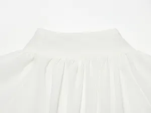 Wit geplooide rok tailleband detail closeup, gladde stoftextuur en nette stiksels.