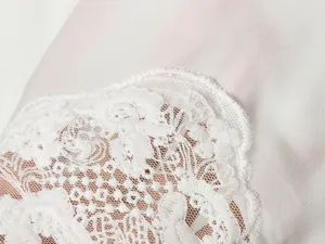 Gedetailleerd overzicht van de elegante dames viscose overhemd top met een fijne witte kantrand.