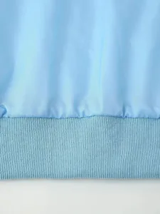 Light blue jacket hem detail close up, showing fine ribbed texture and soft fabric material.