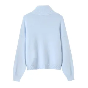 Detailed view of soft light blue turtleneck knit sweater back and fabric texture detail.