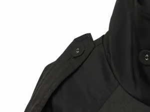 Close-up detail of black women's short trench coat shoulder epaulet and collar button.